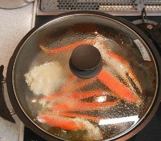カニを殻ごと炒め、煮る