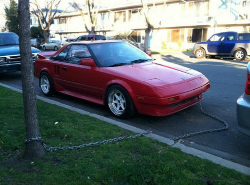 a-red-car-with-chains-and-a-tree.jpg