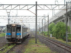 熊本側（奥）からやってきた三角線の列車…右が九州新幹線の高架橋です