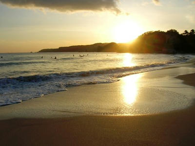 海と夕陽とサーファー