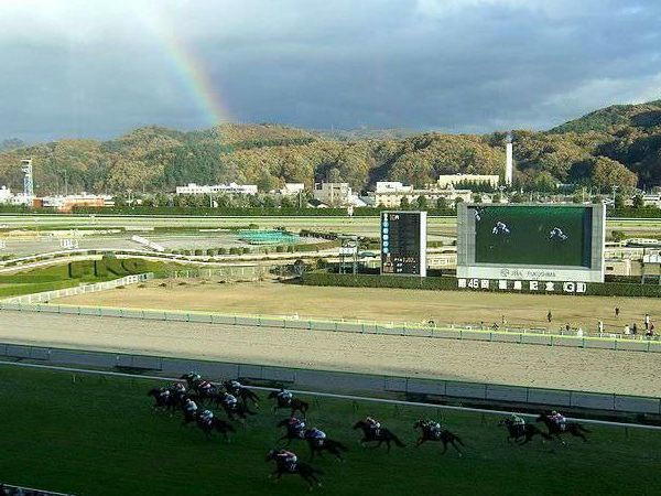 虹をバックに第10レース最後の直線を走る競走馬たち