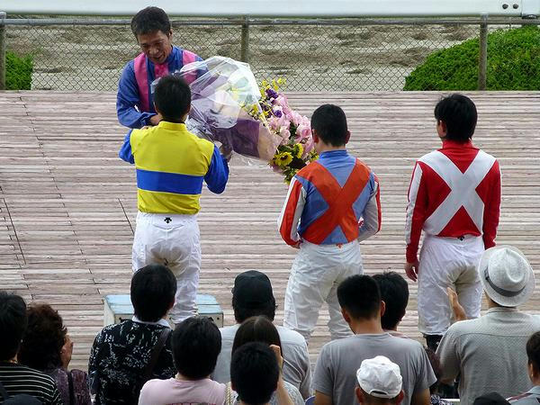 引退式で平瀬騎手から花束を受け取る山中利夫騎手