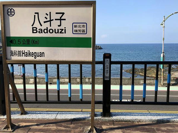 八斗子駅の駅名標と海