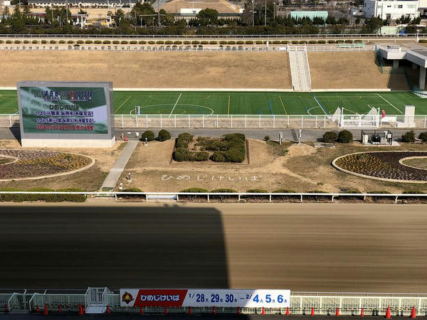 スタンドから見たコースと大型映像装置と災害調整池