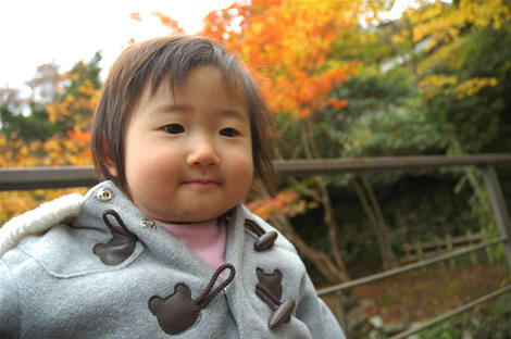 紅葉をバックに満足気なお嬢