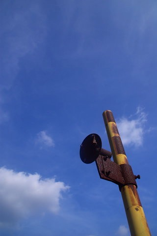 古びたカーブミラーと空。