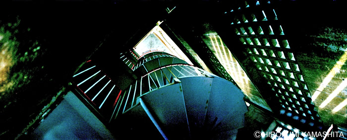 見上げた螺旋階段と差し込む光。