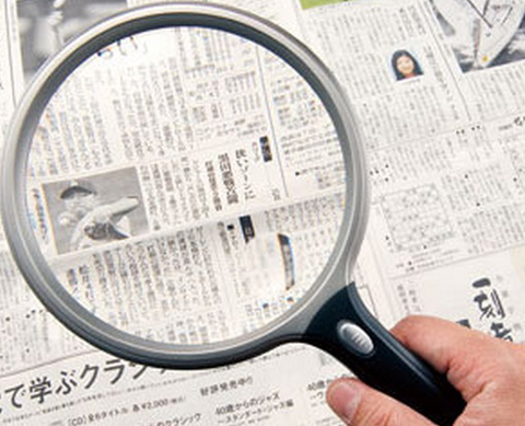 新聞を拡大鏡（虫眼鏡）で見たところ