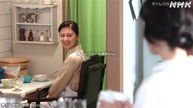 稲の背後のグリーンのカーテンと、ブラウンの衣装