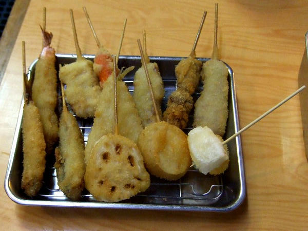 おまかせ！串かつ10本盛り合わせ（今回は味自慢串かつ（牛） 100円、名物ホルモン串 120円、豚バラ 120円、いか 120円、きす 180円、海老 200円、じゃがいも 100円、れんこん 120円、ウインナー 100円、もち 120円、で計1,280円分） 1,250円 と ハタハタ 130円×2本