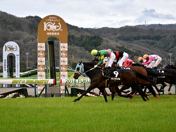 福島競馬場開設100周年記念のゴール板を過ぎる競走馬たち