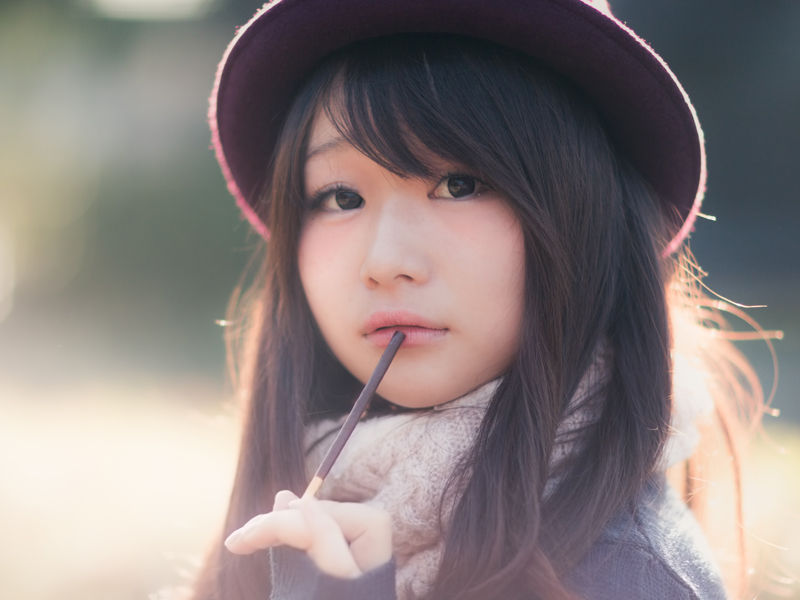 チョコレート菓子(ポッキー)を食べる女性