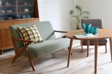 どこか北欧レトロな雰囲気のFIVEソファをメインにしたカフェスタイルのリビングインテリア。スモールスペースでも2シーター＋1シーターという組み合わせが可能なコンパクトサイズながら、北欧木製アームでゆったりした座面を確保。くつろげるソファは、カフェスタイルインテリアには必須アイテムですよね。組み合わせた北欧テーブルは、ソファに座って食事するのにちょうどいい高さ。ランチにティータイム、1日の大半はここでくつろげます。こつこつ集めたお気に入りのコーヒーカップは、インテリアの一部として見せる収納に。心地よく流れる北欧テイストインテリア音楽を聴きながら、お家でのんびりカフェ気分を楽しむのもいいですね。